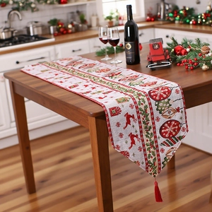 Christmas table runner with festive elk patterns, red tassels on a wooden dining table