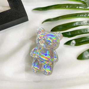Detail of holographic bear phone grip with aurora laser finish on silk background