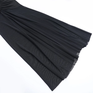 Detail of elegant black mesh fabric showing fine texture and draped pleats of the dress