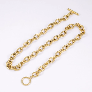 Macro view of gold stainless steel cable chain with OT toggle clasp on white background
