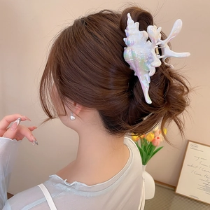 Detailed view of iridescent shell hair claw clip with mother of pearl texture on hair