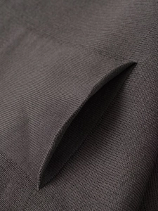 Detail of dense dark taupe knit texture and side pocket stitching on the winter cardigan