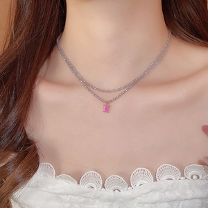 Detail of double-layer beaded necklace with pink rectangular pendant on model