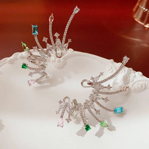 Close-up of silver ear cuff with colorful teardrop zircons on white relief tray