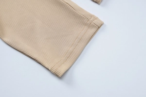 Détail de l'ourlet en maille côtelée beige avec double couture et texture de qualité