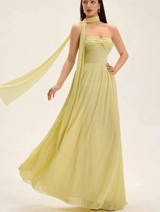 Detail view of a pale yellow tube dress with floating neck scarf and layered mesh fabric