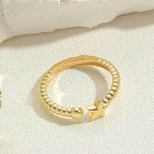 Macro detail of gold star and bead open ring with textured bamboo band design