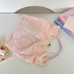 Detailansicht der rosa Tragetasche mit Schmetterlingsstickerei und Seilgriffen
