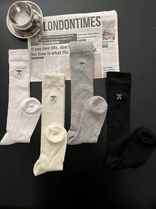 Flat lay of cotton calf socks in four colors with embroidered bows and vertical stripes