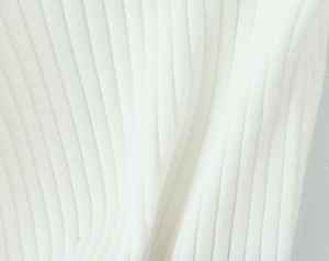 Close-up of white ribbed knit fabric showing soft texture and elastic vertical stitch