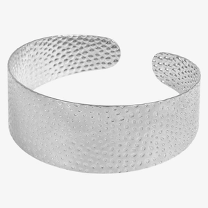 Detail view of silver hammered metal texture on wide stainless steel cuff bracelet