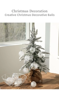 Detail of clear Christmas balls with white snowflake patterns on a miniature tree