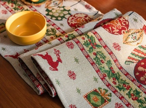Close-up of woven Christmas table runner with reindeer and snowflake jacquard patterns