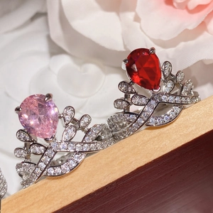 Close-up of crown rings with pink and red pear-cut stones and cubic zirconia