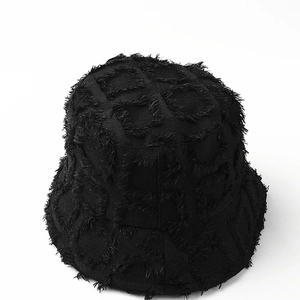 Detailed close-up of a black frayed plaid bucket hat showing the distressed fabric texture