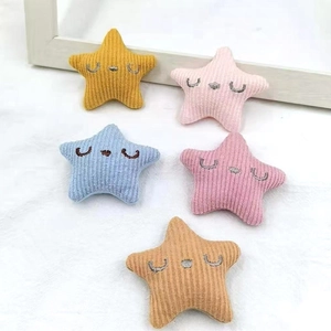 Detail of five colorful corduroy star accessories with cute embroidered facial features