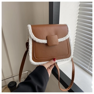 Détail d'un sac bandoulière marron avec garniture en fausse fourrure blanche et cuir mat