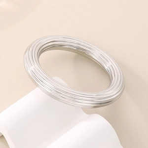 Détail du bracelet creux en acier inoxydable argenté avec design rayé multicouche