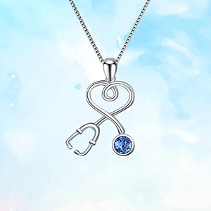 Minimalist silver stethoscope heart necklace with a blue gemstone pendant on blue background