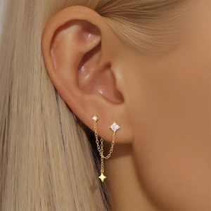 Macro view of gold S925 sterling silver chain earrings with star zircon studs