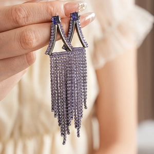 Detail of purple long tassel earrings with sparkling rhinestones and geometric design