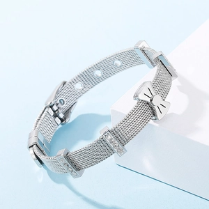 Detail view of silver mesh bracelet featuring a sparkling crystal bow on white stand