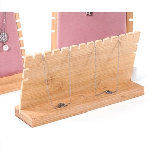 Detail of pink velvet necklace stand with bamboo base and elegant pearl pendant jewelry