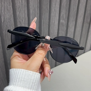 Close-up of classic black oval frame sunglasses with smooth texture and high-quality finish