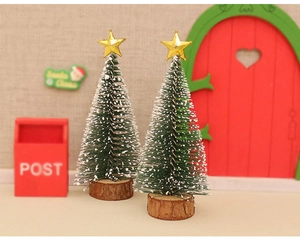 Miniature Christmas pine trees with snow effect and golden stars on wood base