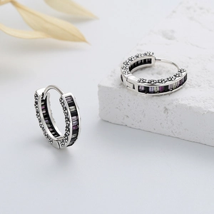 Detailed macro view of S925 silver hoop earrings with vintage floral relief and zircon