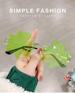 Detail of green clover-shaped rimless sunglasses with pearl accents and metal temples