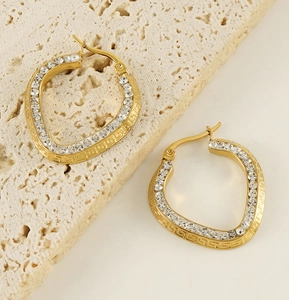 Detail of 18K gold plated heart earrings with pavé crystals and Greek key patterns