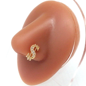 Golden dollar sign nose stud with sparkling cubic zirconia on a realistic silicone model