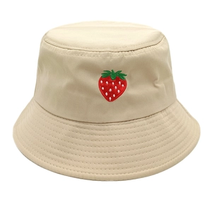 Detail of strawberry embroidery and reinforced stitching on beige cotton bucket hat
