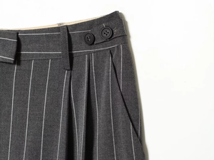 Détails du pantalon gris foncé à rayures avec deux boutons et des poches latérales