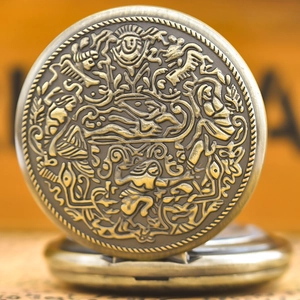 Close-up of vintage bronze pocket watch featuring intricate embossed mythological relief