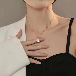 Elegante drehbare Sonnenblumen-Halskette in Gold mit Zirkonia, getragen von einem Modell