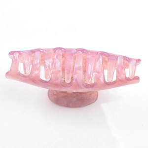 Detail of pink marble pattern resin hair claw clip with glossy acetic acid finish