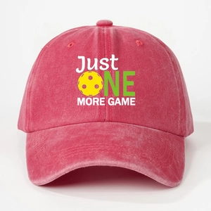 Detail view of Just One More Game print on red washed cotton baseball cap with pickleball icon