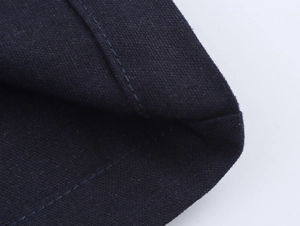 Detailed close-up of dark blue fabric texture with precise double-stitched sewing details