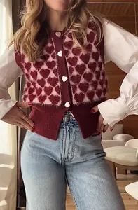 Détails d'un gilet en tricot à motif cœur rouge et rose avec des boutons en forme de cœur
