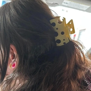 Detail showing creative yellow hollow cheese shaped hair claw clip on brunette hair