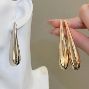 Elegant silver and gold metallic teardrop earrings with a polished mirror finish