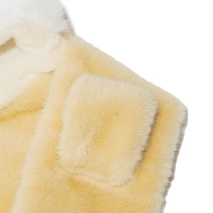 Macro shot of plush cream faux fur with white accent detailing for warm winter hat