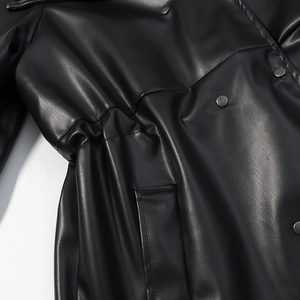 Close-up of black leather coat texture featuring metallic buttons and waist drawstring