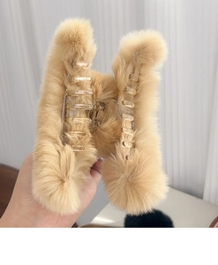 Detail of plush brown faux rabbit fur hair claw clip with transparent plastic inner teeth