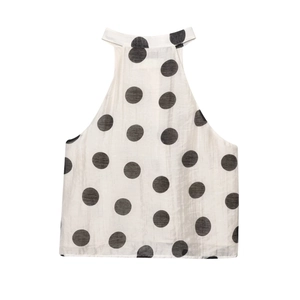 Detail shot of the polka dot halter neck top with large black dots on white fabric
