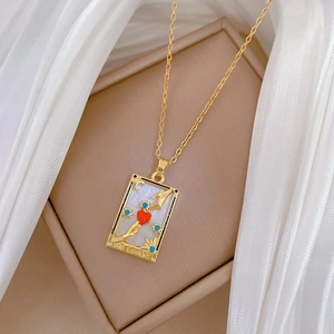 Gold tarot card lovers necklace with red heart and blue crystals on mother-of-pearl base