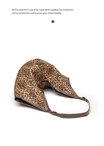 Detail of leopard print tote bag with brown leather shoulder strap and crescent design
