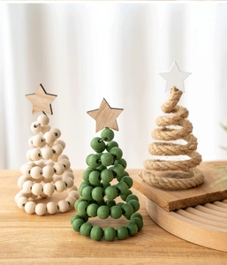 Handcrafted wooden Christmas tree ornaments with beads and jute rope on a tray